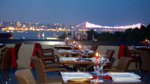 A restaurant with tables set for dining, overlooking a cityscape and a bridge. - Erboy Hotel (Istanbul)