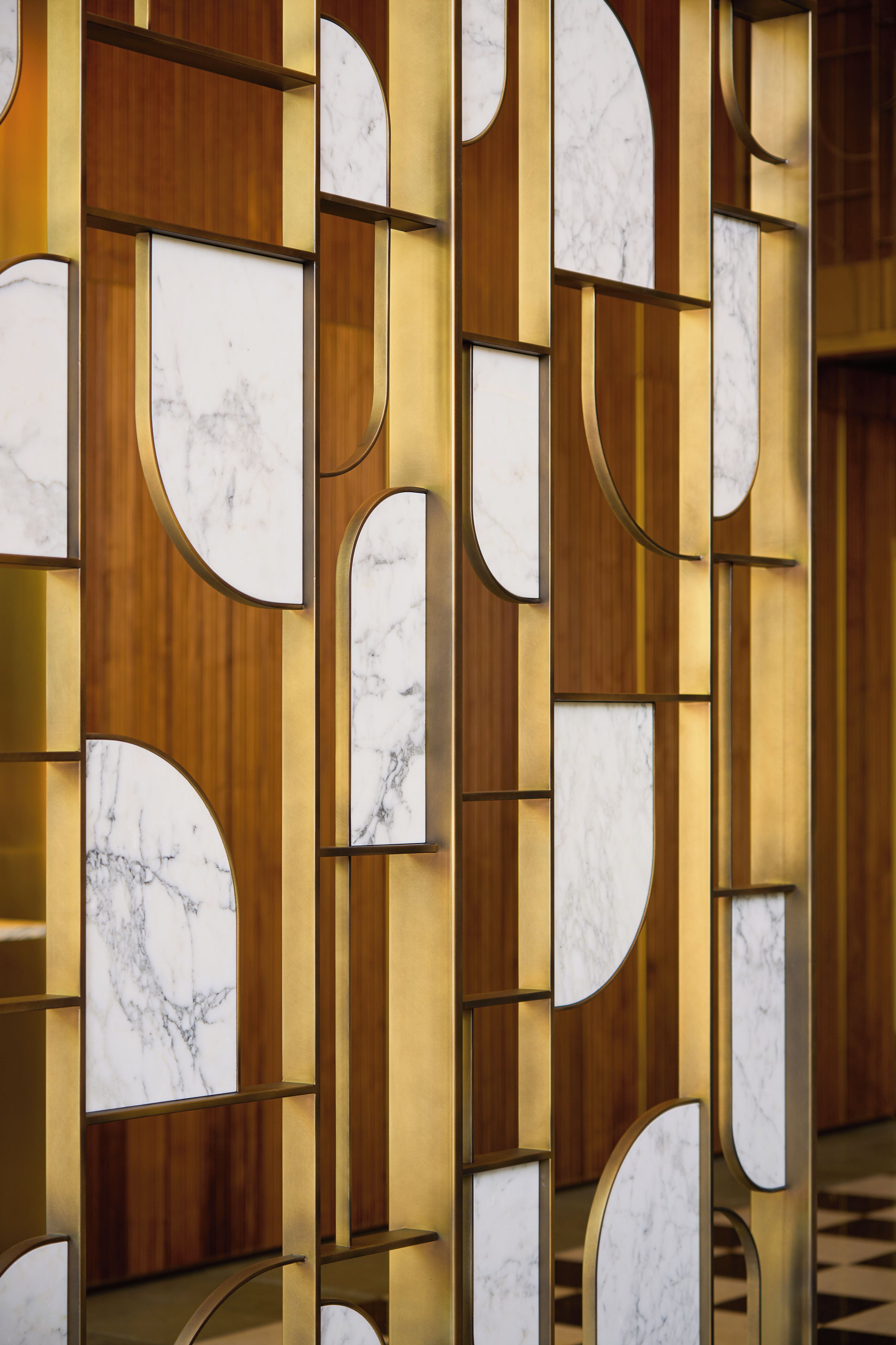 Paredes com padrões geométricos e detalhes em mármore.