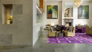 Un vestíbulo moderno con un rug geométrico, muebles contemporáneos y obras de arte en las paredes.