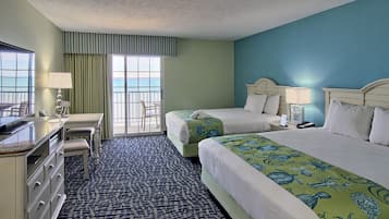 Une chambre d’hôtel avec deux lits, un bureau, une commode et une vue sur la mer.