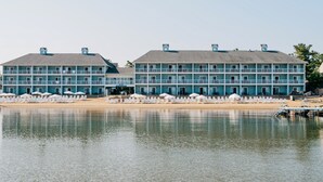 Um hotel grande, com várias andares, varandas e localização à beira-mar.