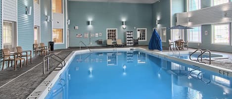 An indoor swimming pool with tiled walls and a clear blue pool.