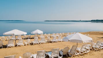 På stranden, solstolar, parasoller och strandhanddukar