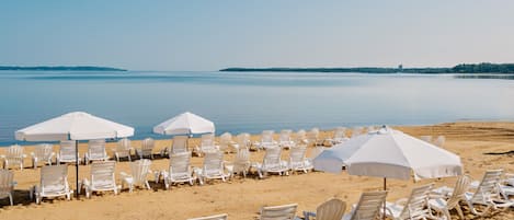 På stranden, solstolar, parasoller och strandhanddukar