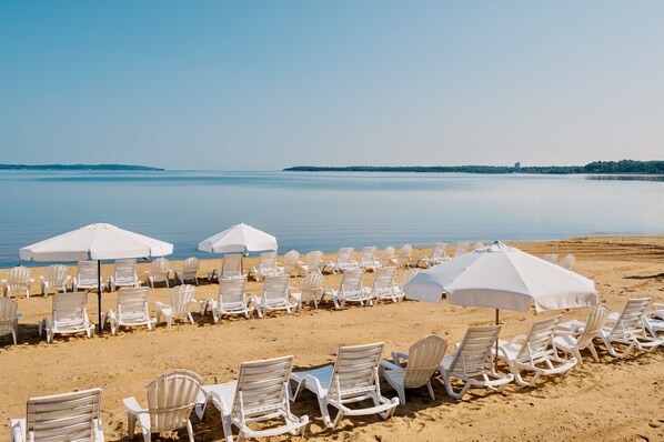 En la playa, camastros, sombrillas y toallas de playa 