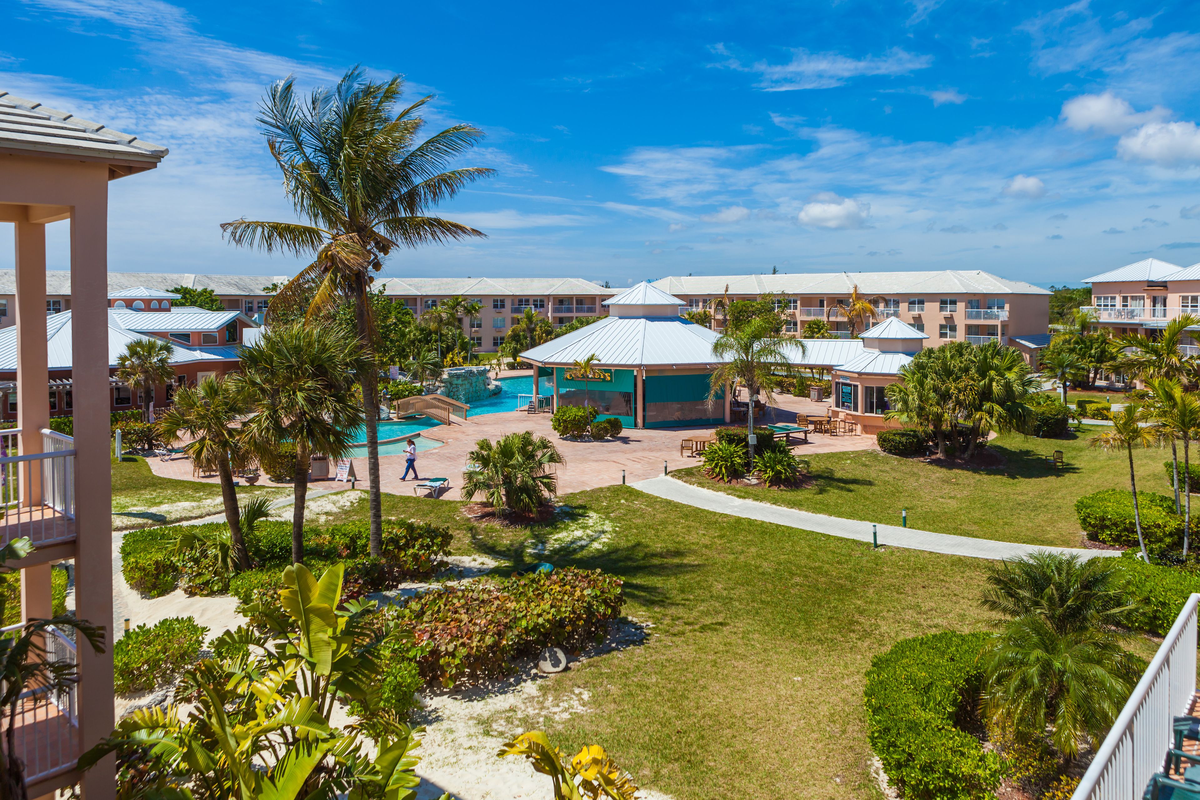 Um resort com vários edifícios, uma piscina e jardins bem cuidados.