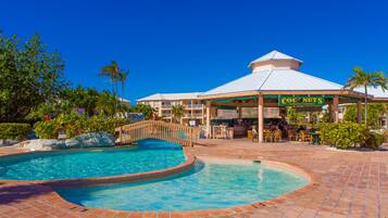 A resort with a pool, a restaurant named 'Coconuts', and a covered seating area.