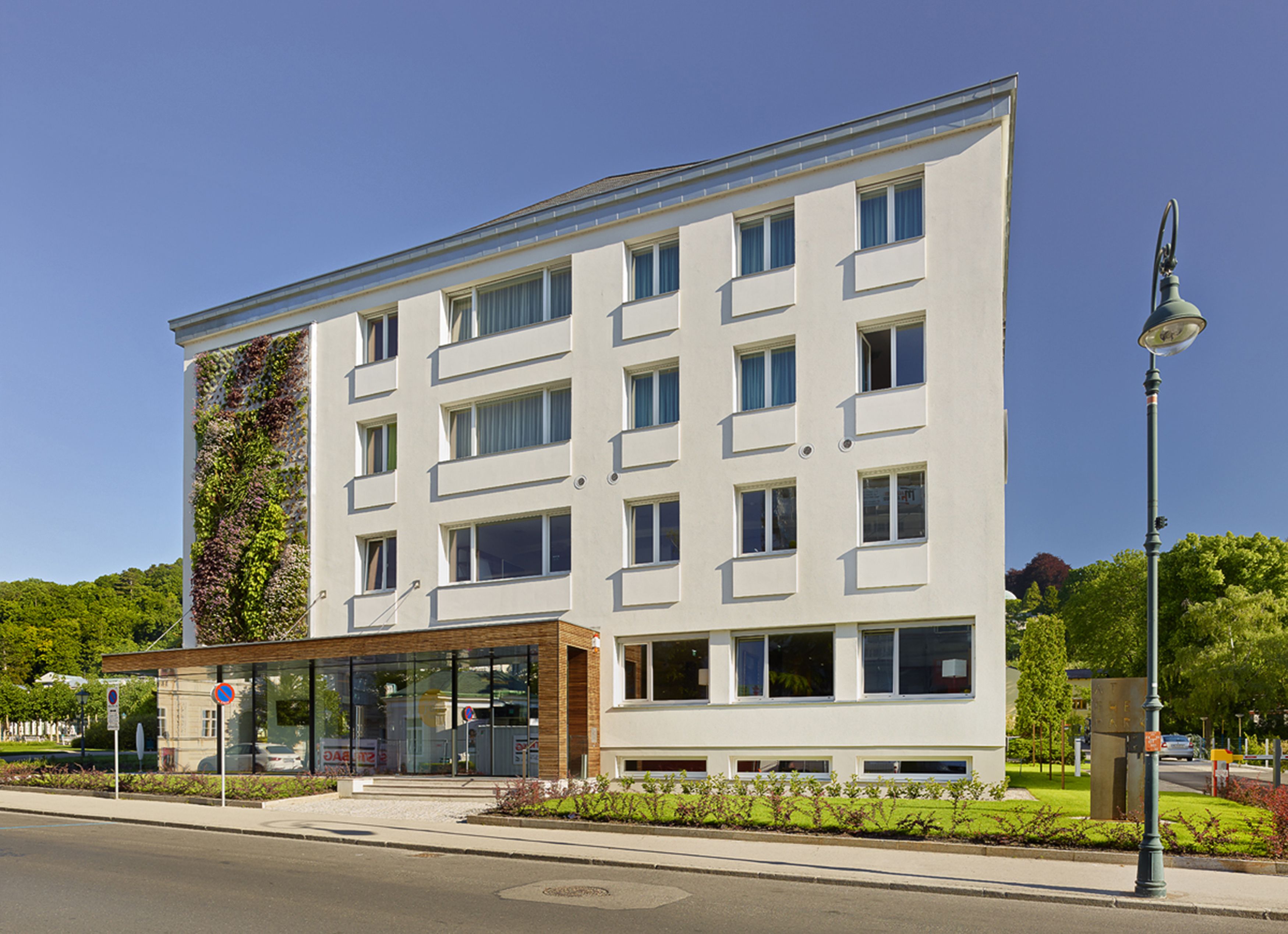 A modern building with a flat roof, multiple windows, and a glass entrance.