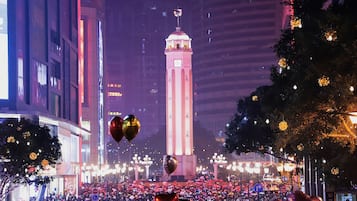 A crowded street with a prominent clock tower in the background.