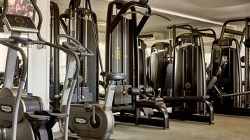 A gym with various exercise machines including treadmills, elliptical trainers, and weight machines.
