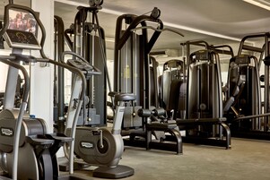 A gym with various exercise machines including treadmills, elliptical trainers, and weight machines.
