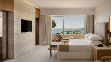 Une chambre d’hôtel moderne dotée d’un grand lit, d’un téléviseur fixé au mur, d’un bureau avec une chaise et offrant une vue sur la mer.