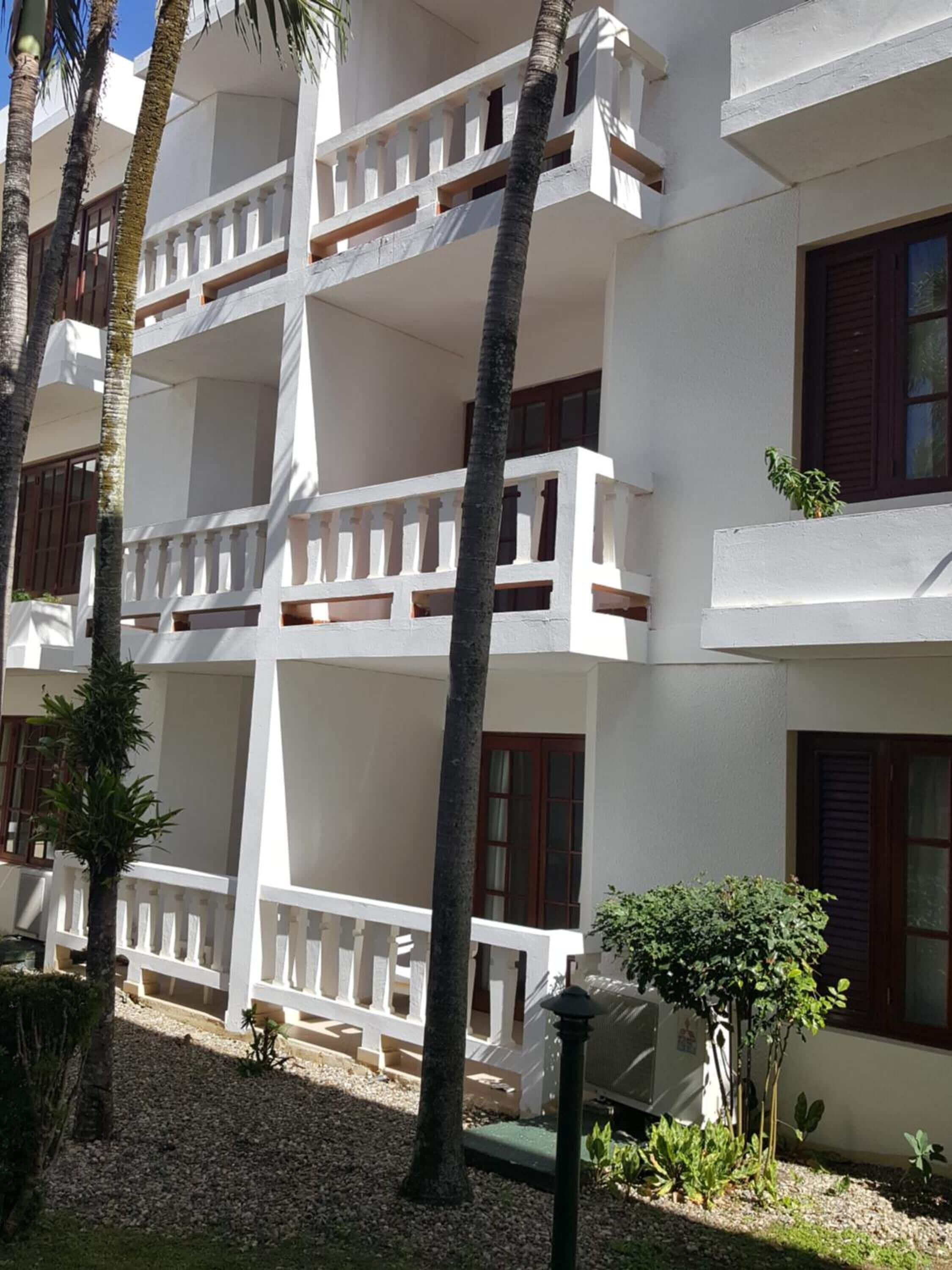 A multi-story building with white exterior walls and balconies.
