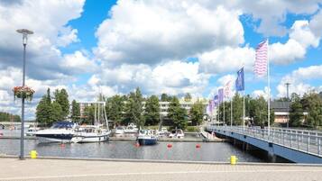 A marina with boats docked, a pedestrian bridge, and flags.