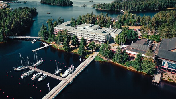 A large building with a casino sign, surrounded by water and trees. - Spahotel Casino (Savonlinna)