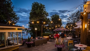 An outdoor patio area with seating, tables, and string lights. - Spahotel Casino (Savonlinna)