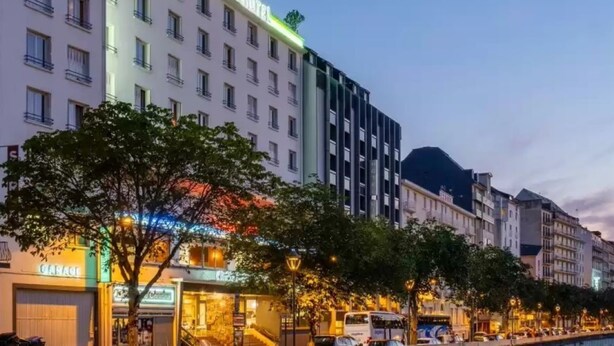 A hotel with multiple floors, flags, and a prominent sign. - Hotel Christina Lourdes (Lourdes)