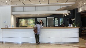 A reception desk with a map, a clock, and a vase with flowers. - Hotel Christina Lourdes (Lourdes)