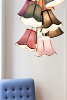A wall with a series of hanging lamps in various shapes and sizes.
