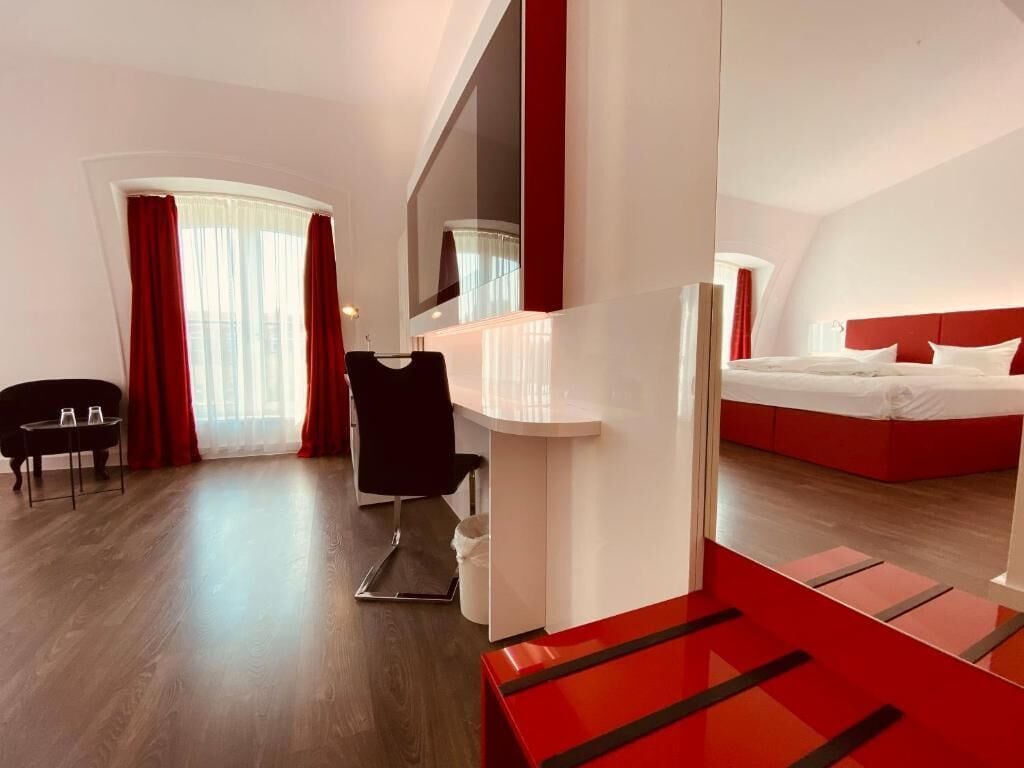 Ein modernes Hotelzimmer mit einem großen Bett, einem Schreibtisch und einem Stuhl.