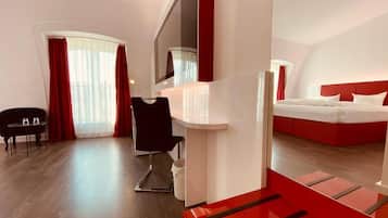 Una habitación de hotel moderna con una cama grande, un escritorio y una silla.