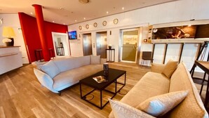 Een moderne hotel lobby met een lichtkleurige bank, een zwarte salontafel en een rode accentmuur.