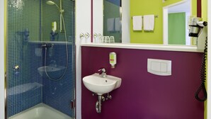 Un baño con ducha, lavamanos e inodoro.