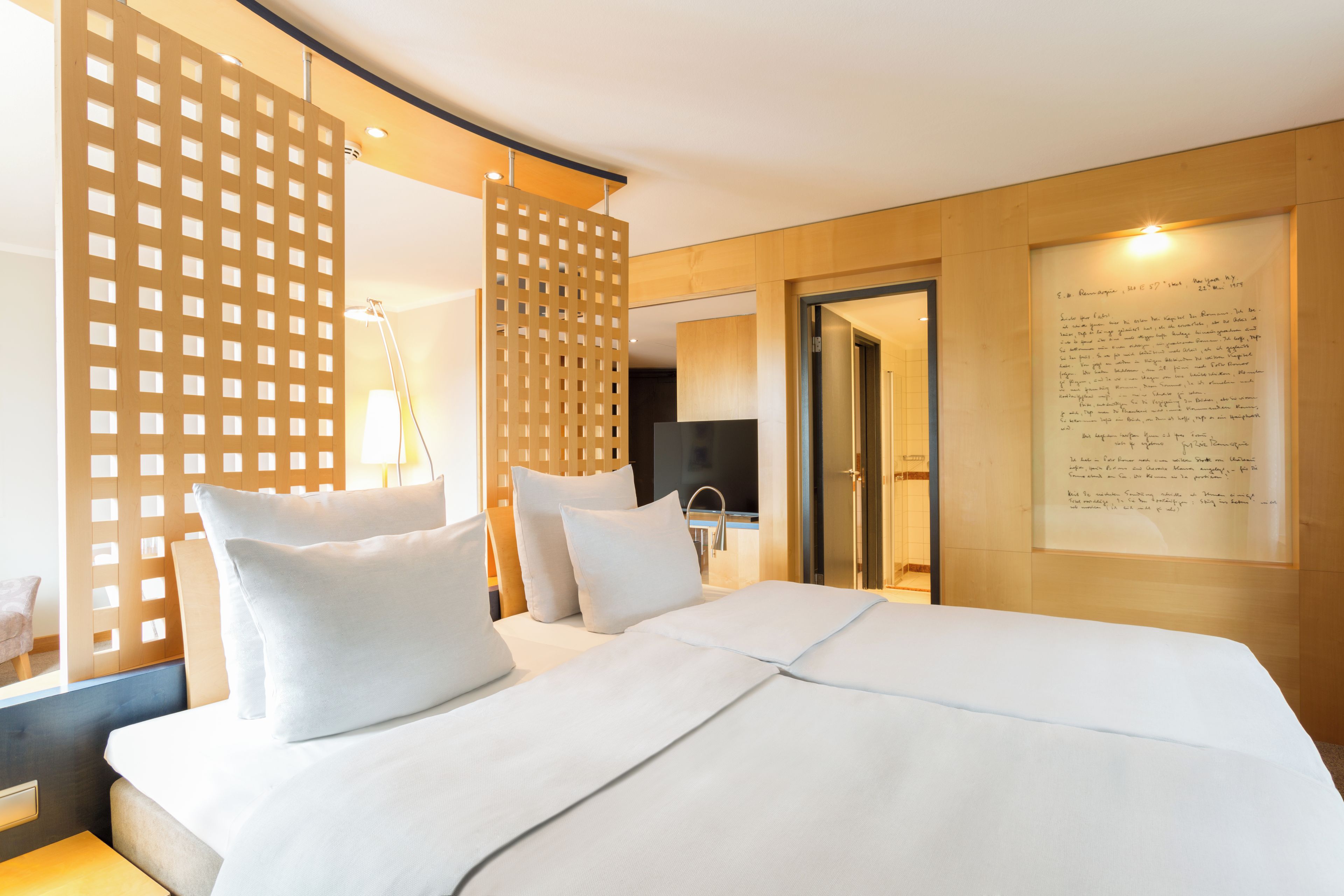 Ein Hotelzimmer mit einem großen Bett, einer Holzwand, einem Schreibtisch und einem Spiegel.