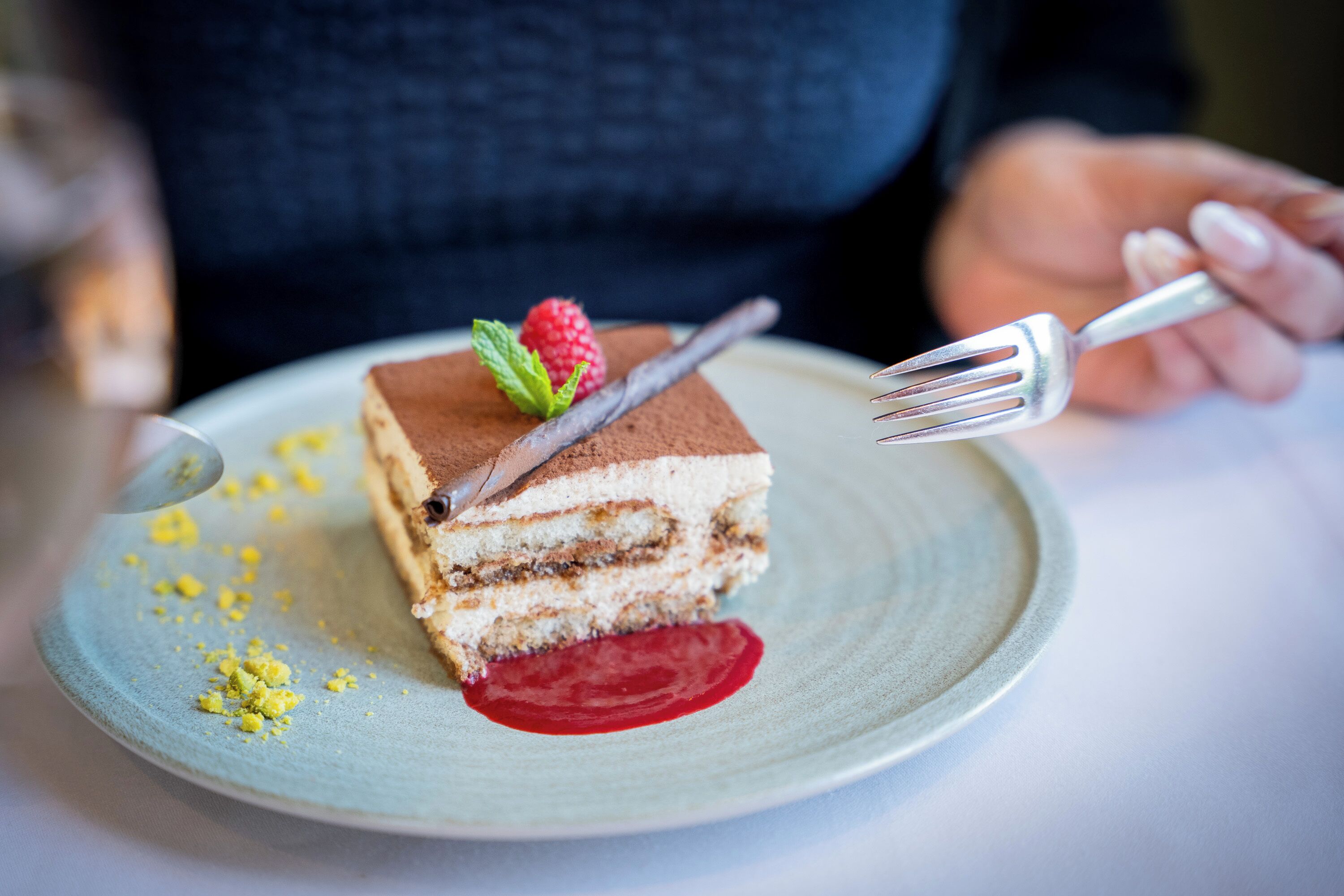 A slice of layered dessert on a plate with a fork.