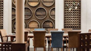 A dining area with round wooden barrel walls, a central table, and chairs.