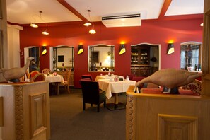 A restaurant with red walls, multiple tables, and chairs. - AKZENT Hotel Berg´s Alte Bauernschänke (Ruedesheim am Rhein)