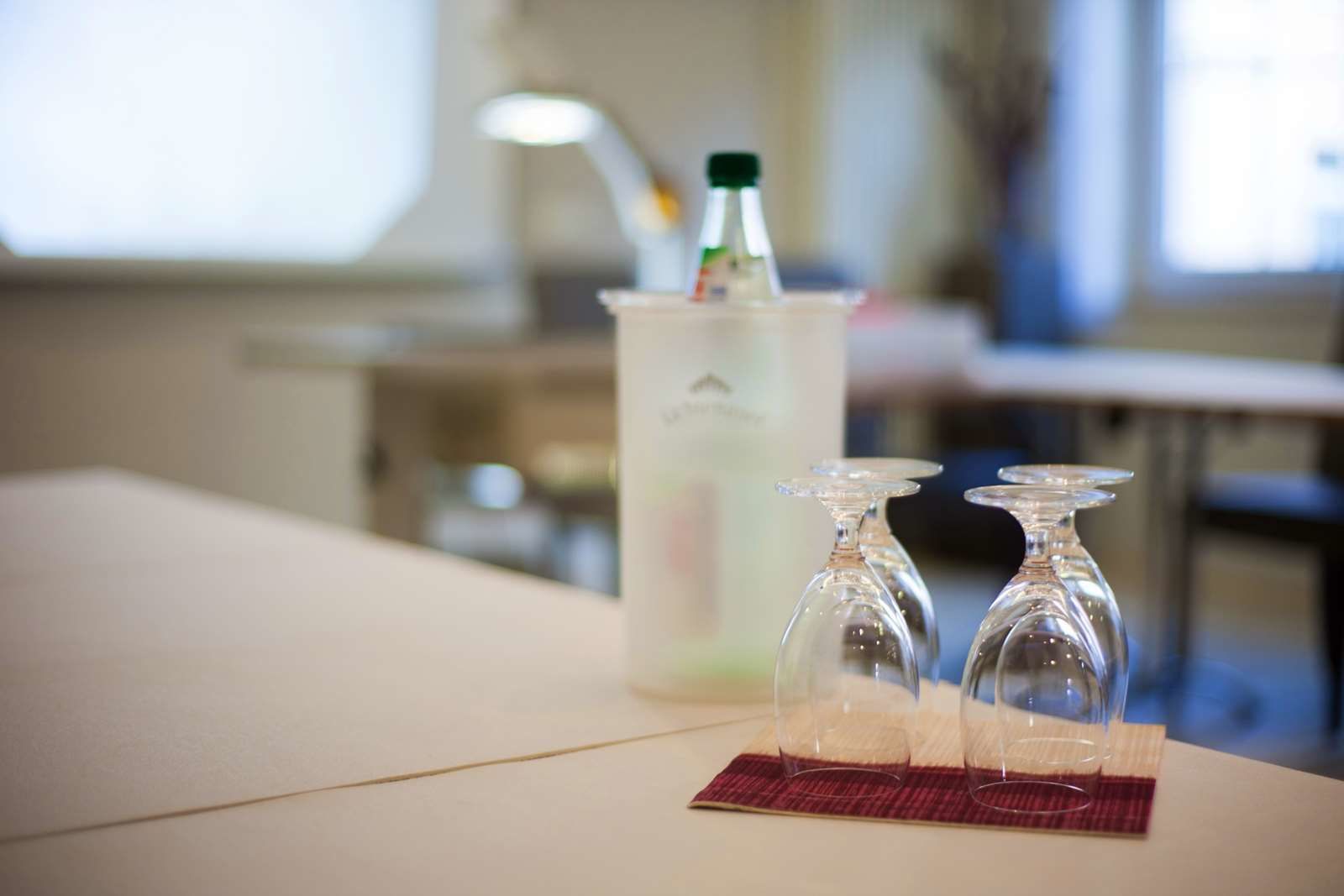 Una mesa con dos copas de vino vacías y una botella de agua.