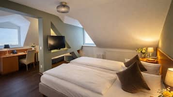 Una habitación de hotel moderna con una cama grande, un escritorio, un televisor y un tragaluz.