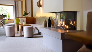 Una sala de estar moderna con chimenea, un sofá, otomanas y una mesa de centro.