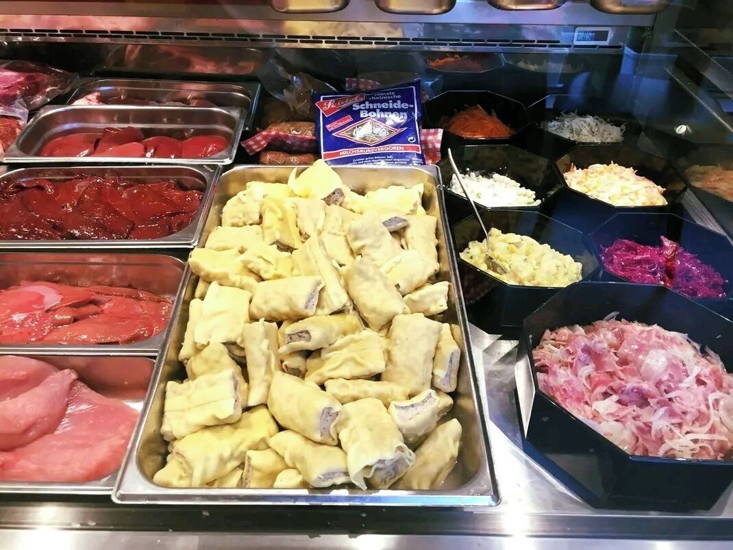 Mostrador de carnes con diferentes cortes y productos envasados.