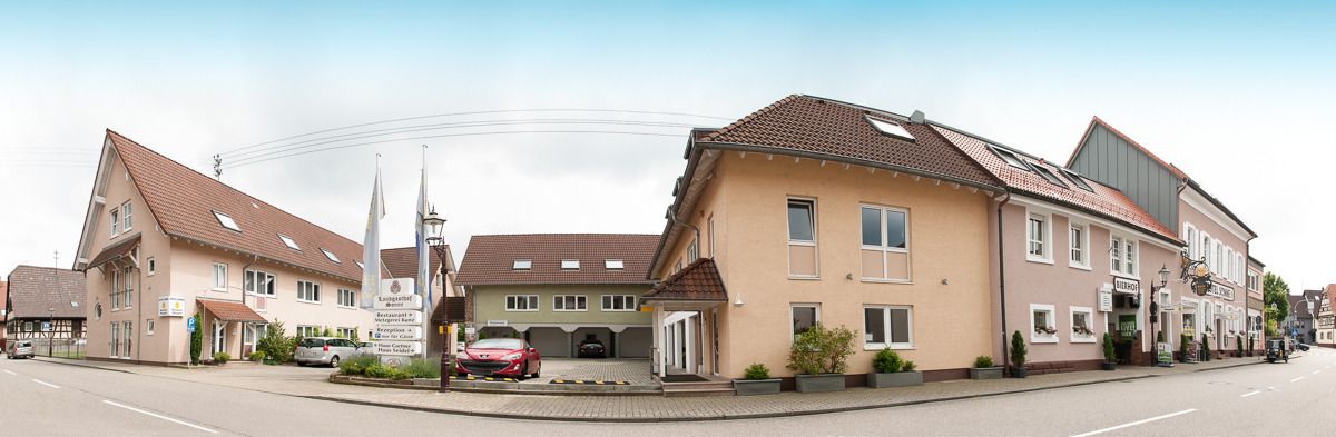 Vista de una calle en un pueblo con arquitectura europea tradicional, incluyendo un edificio con un letrero que dice 'Hotel'.