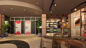 Un interior moderno con una recepción, una zona de estar y un bar con estantes llenos de bebidas.