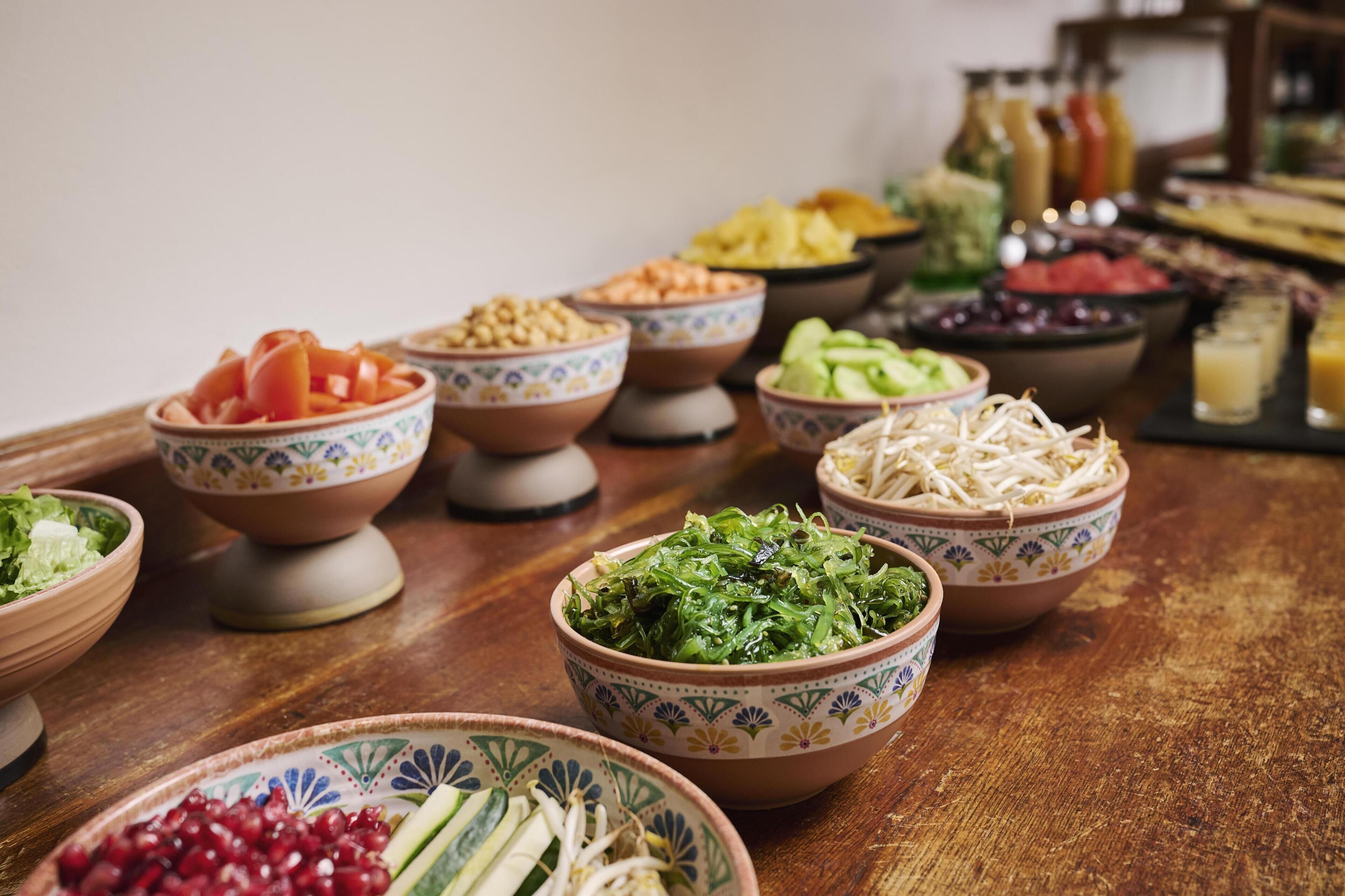 Une variété d’aliments présentés dans des bols sur une table en bois.