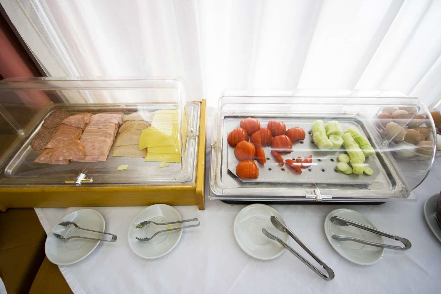 Un buffet proposant une variété de plats, notamment des viandes, des fromages et des légumes.