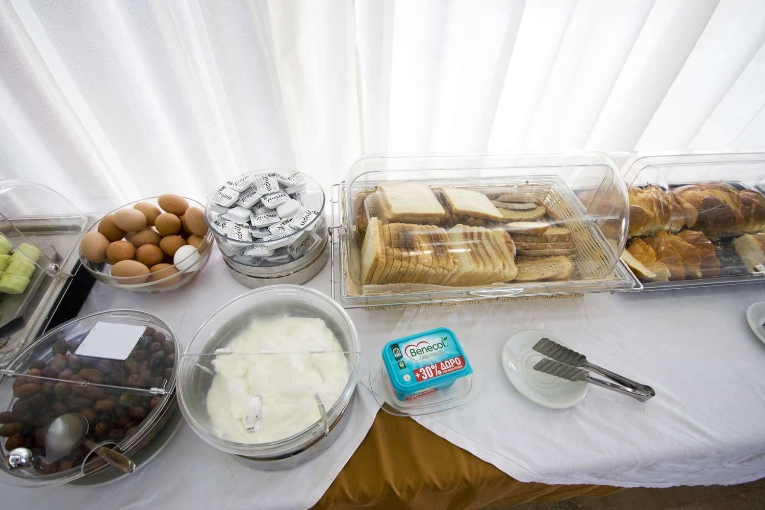 A buffet table with various food items including eggs, bread, and cheese.