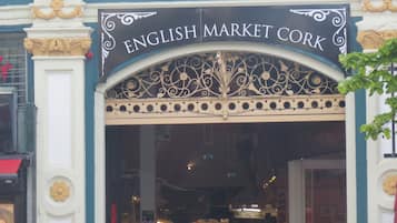 De ingang van de English Market in Cork, met sierlijk metaalwerk en een bord boven de deur.