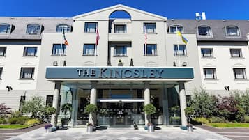 Experience the grand entrance of The Kingsley, featuring a central archway and beautifully maintained grounds.