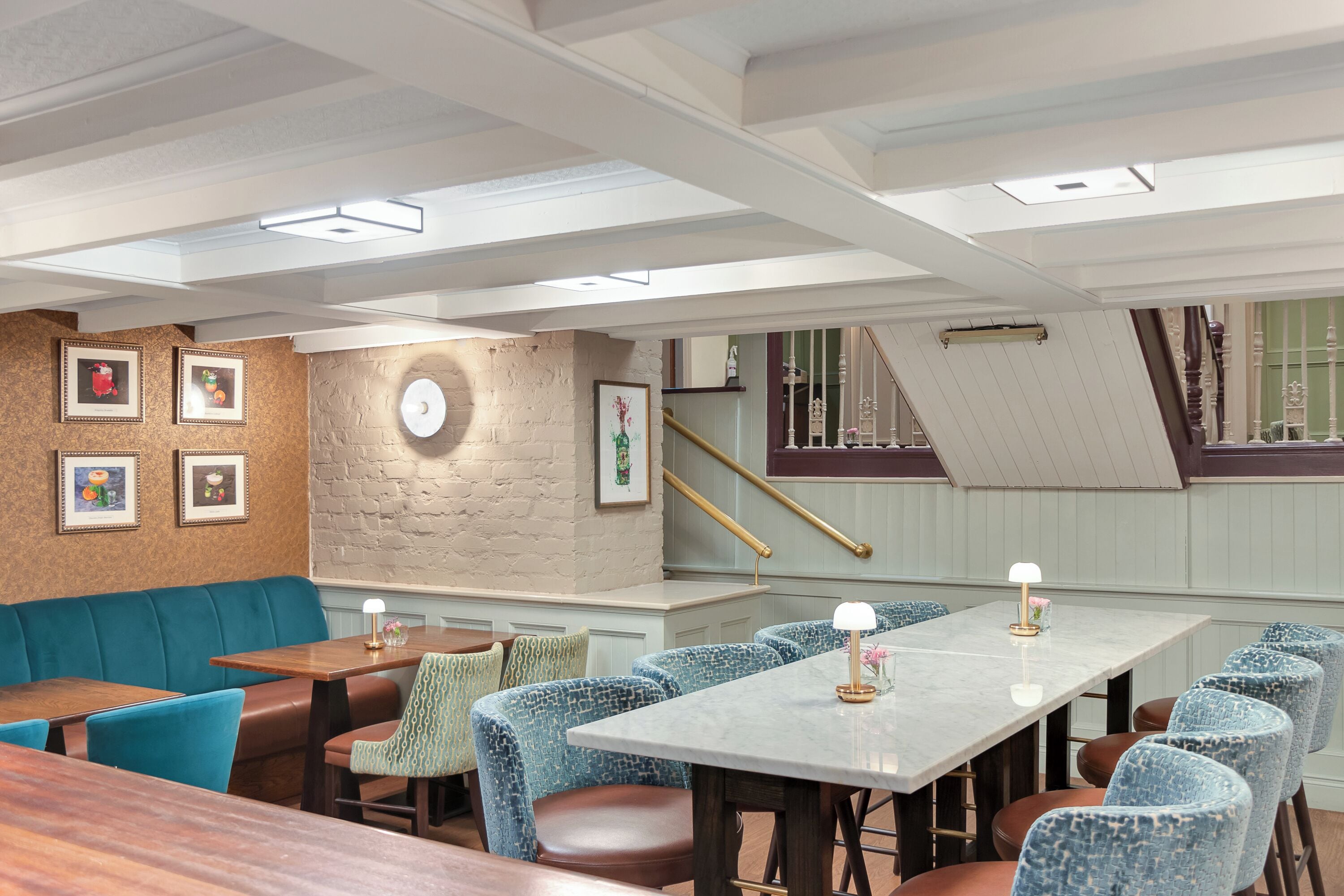 Un restaurante con techo alto, vigas a la vista y una variedad de asientos, incluyendo cabinas y mesas.