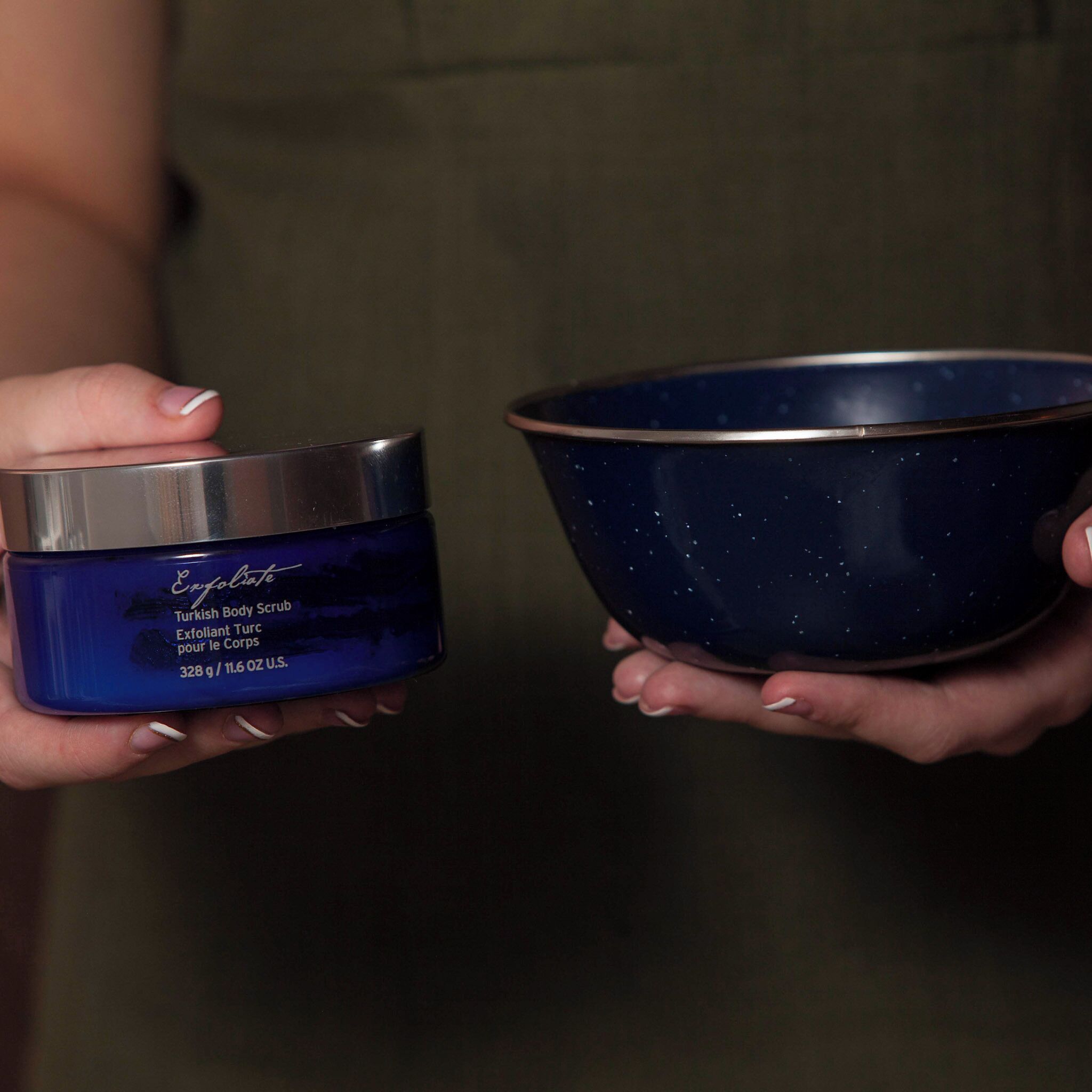 A person holding a blue container and a dark blue bowl.