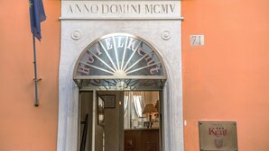La entrada del Hotel Kemp, con un cartel visible sobre la puerta y una placa debajo.