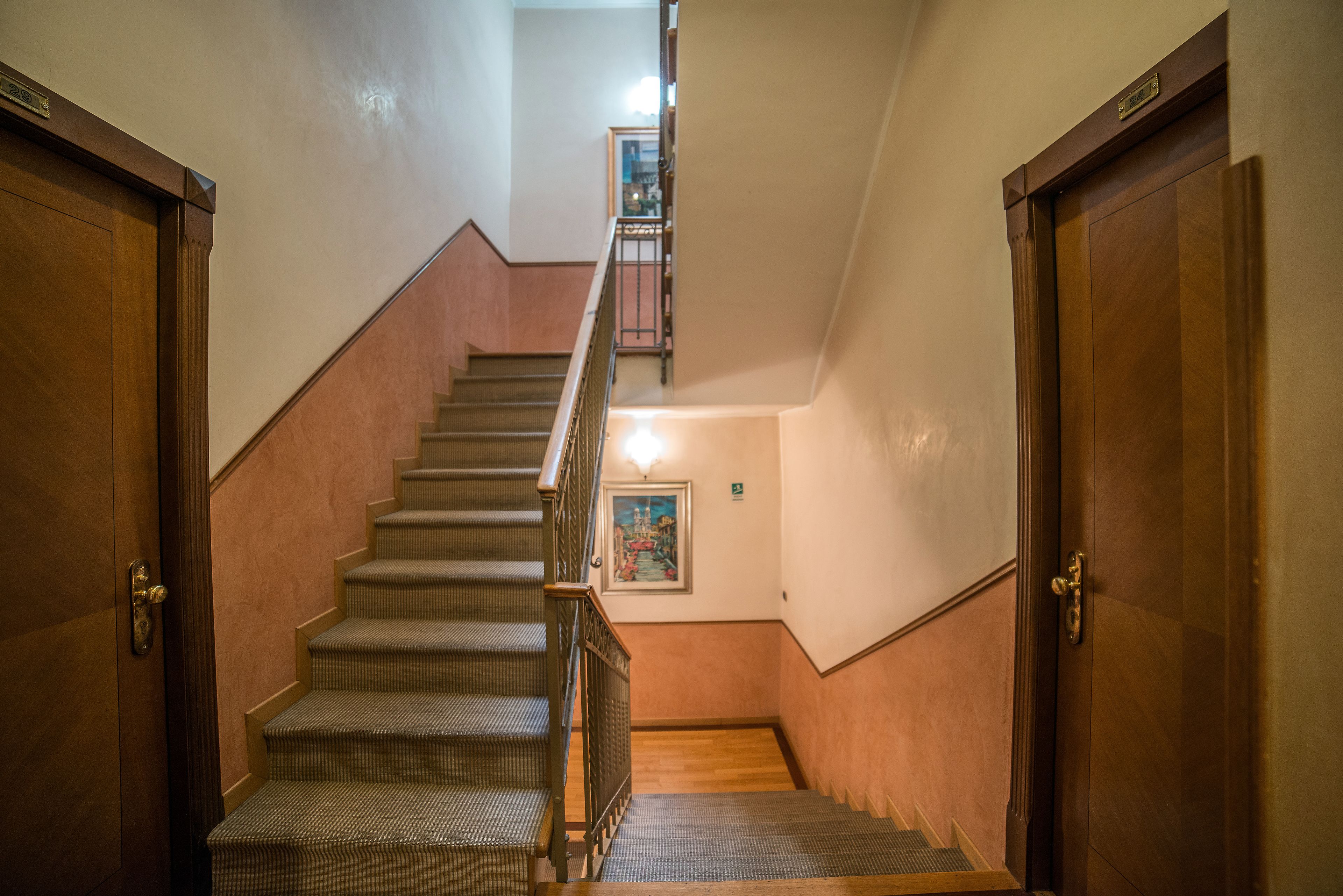 A staircase with wooden doors and a handrail, leading to an upper floor.
