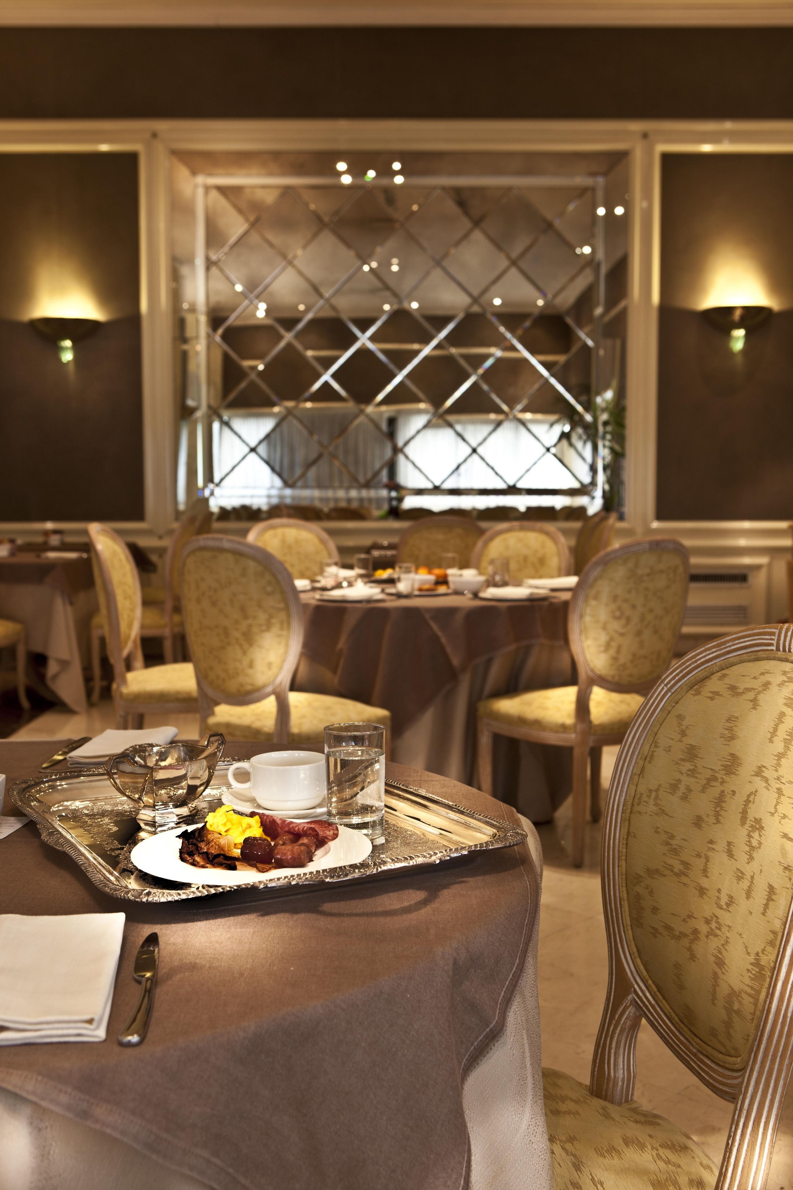 A dining area with tables set for a meal, including plates with food and drinks.