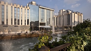 A modern building with large windows and a water feature in front. - Hotel Leon d'Oro (Verona)