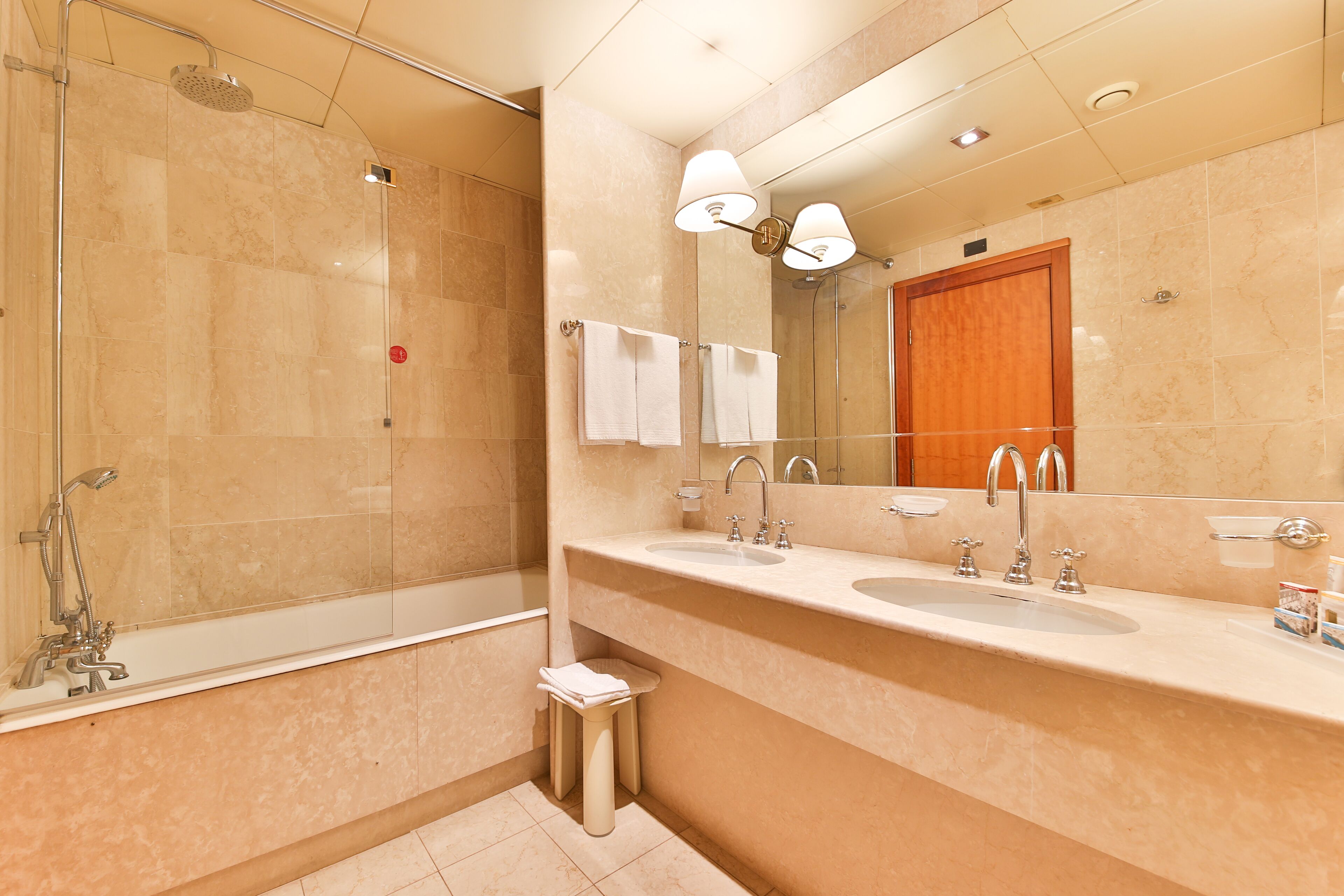 Une salle de bain moderne avec une douche à parois de verre, un meuble-lavabo à deux vasques et un grand miroir.