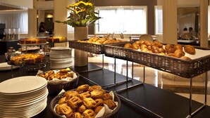 A buffet table with various pastries and desserts, including croissants and cakes, arranged on plates and in baskets. - Hotel Leon d'Oro (Verona)